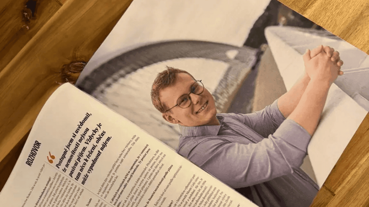Rozhovor v Rentiéru rozevřený na kuchyňském stole — celostránková fotka Dennise Vymera vedle citátu o tom, že nemovitosti nejsou pasivní příjem